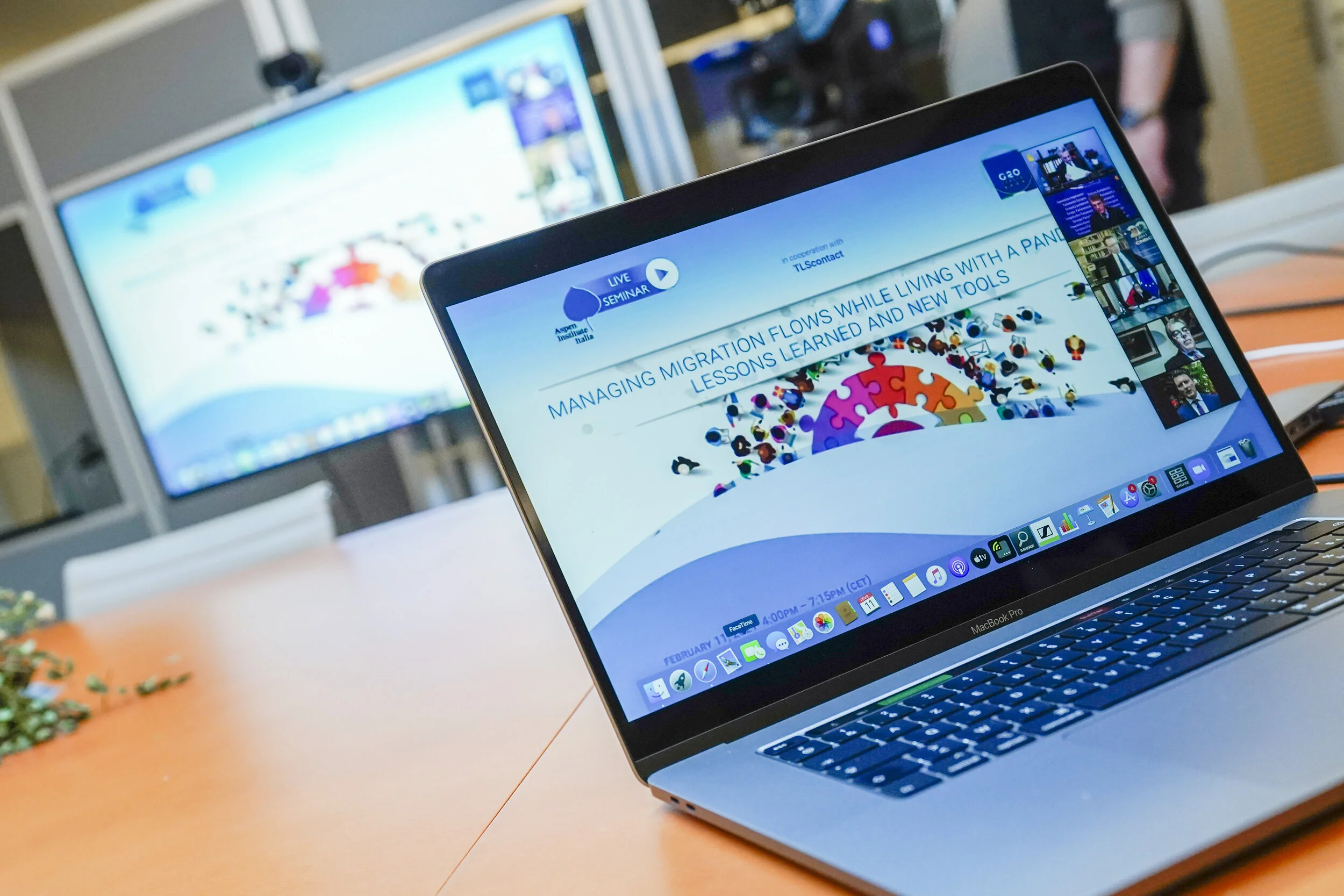 Un ordinateur portable et un second écran ouverts sur une table de travail, avec des pages web affichées.