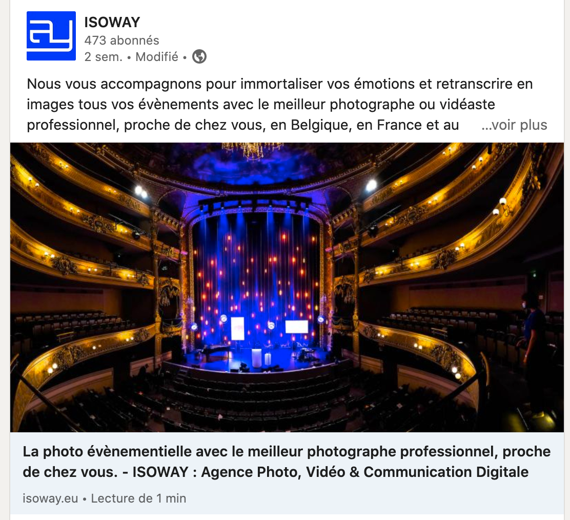 Intérieur d'un théâtre luxueux avec des balcons dorés et une scène illuminée par des lumières colorées.