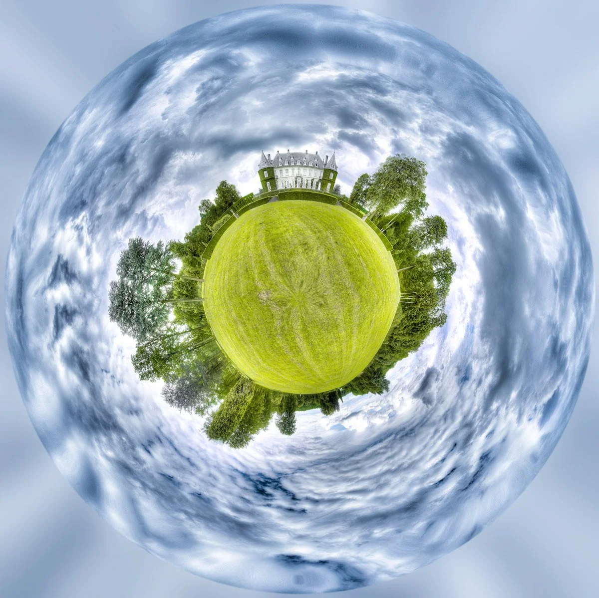 A ‘little planet’ effect image showing a house surrounded by a green lawn and trees under a cloudy sky.