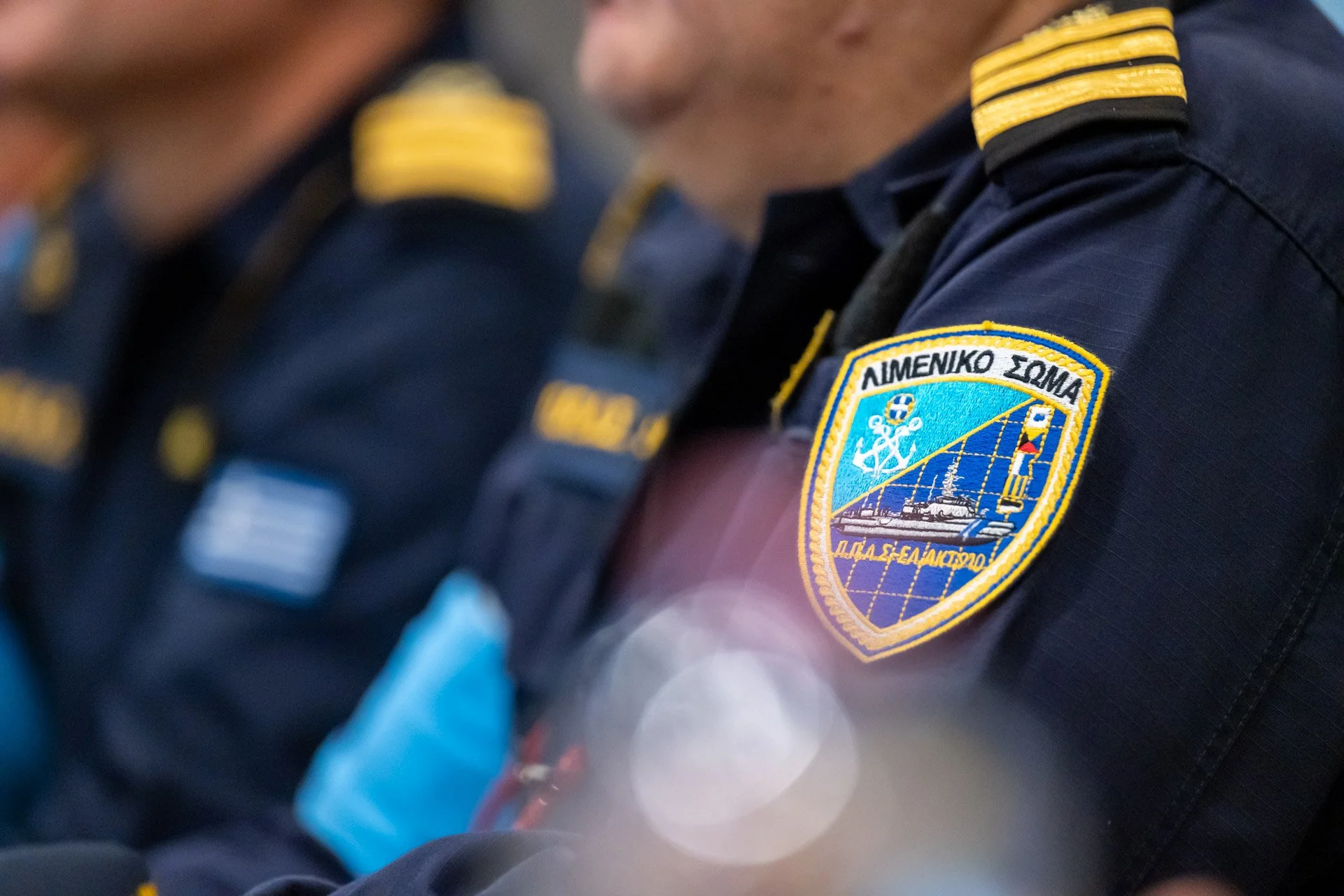Uniformes de la police maritime avec écussons, gros plan, en salle de conférence.