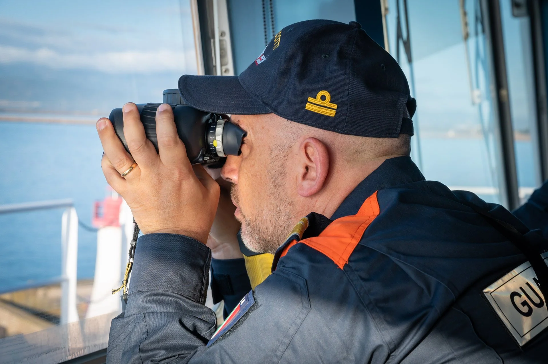 Reportage photo pour l'agence européenne Frontex d'un homme en uniforme regardant à travers des jumelles.