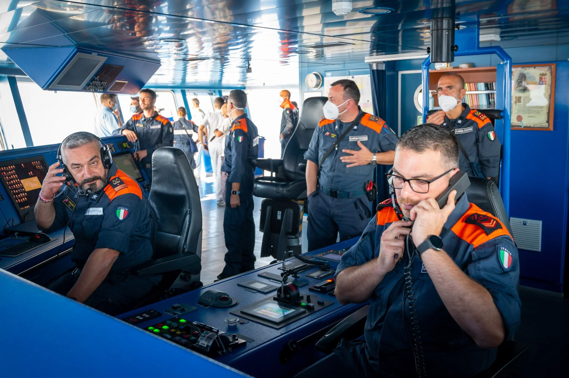 Des membres d’équipage en uniforme travaillent aux consoles de la passerelle d’un navire lors d’une opération Frontex.