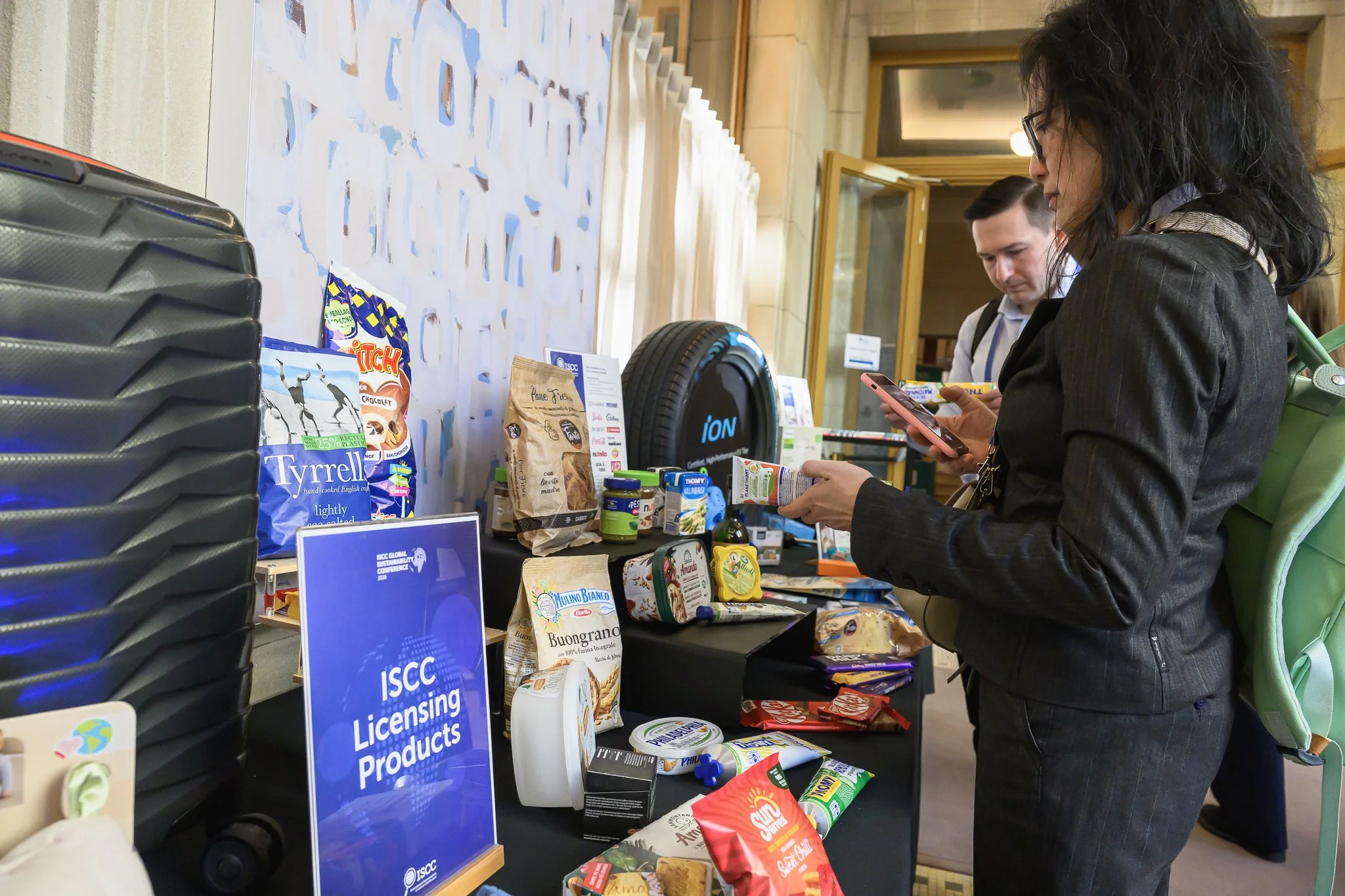 A woman examines products on an ISCC licensing display table.