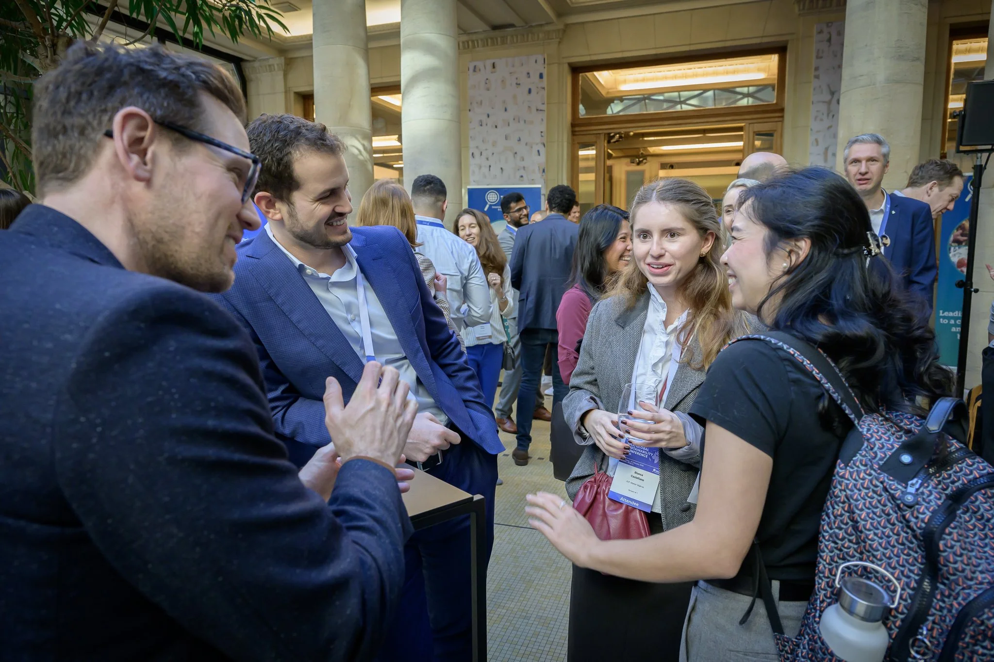 Four participants discuss together around a tall table in the lobby.