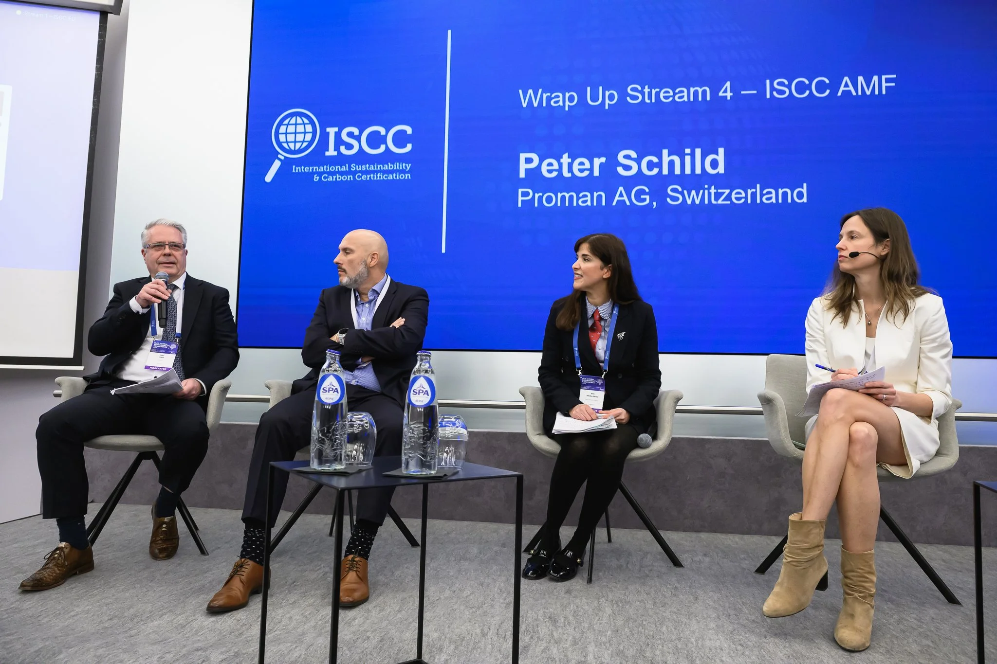 Four panel participants sit beneath a slide summarising the ISCC AMF conference stream.