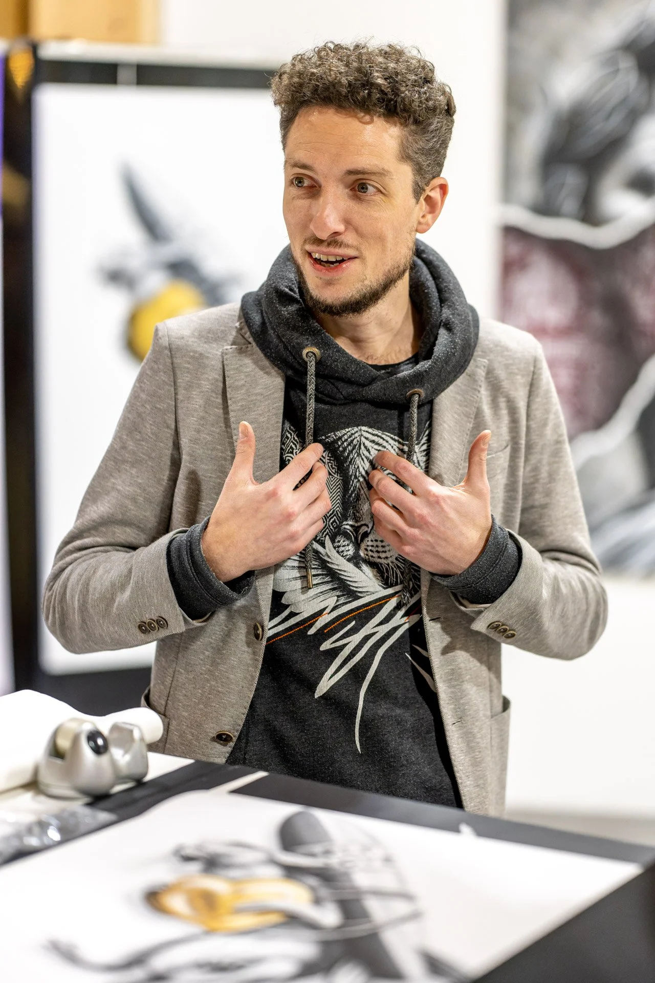 Martin Gilson accompagne ses propos de gestes des mains lors du finissage de l’exposition de Noir Artist.