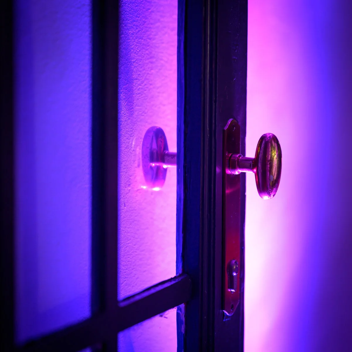 Metal door handle under a purple light