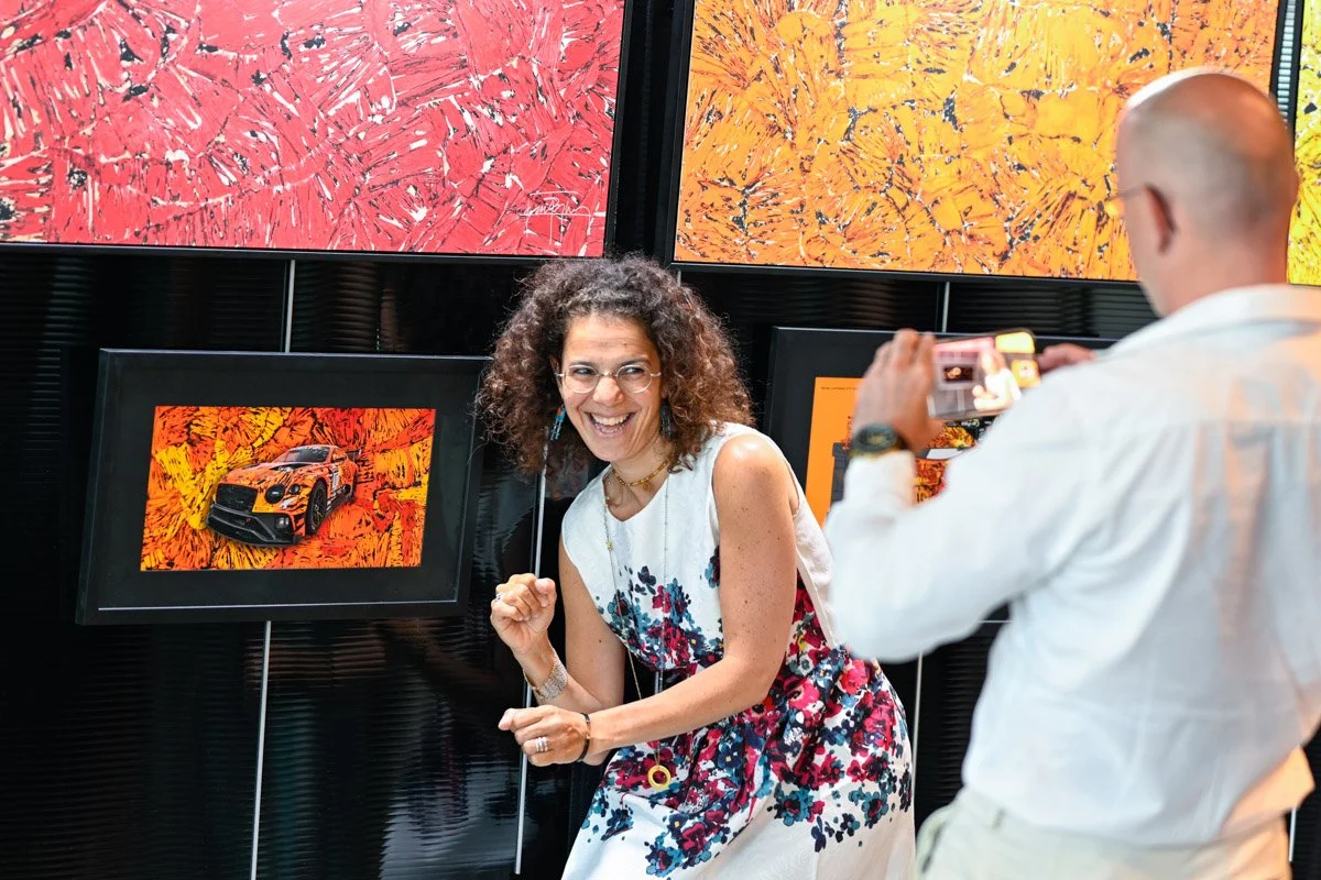 Photo professionnelle de Hanane Risayindi photographiée par le photographe pro de ISOWAY devant des tableaux lors d'un événement à Nivelles