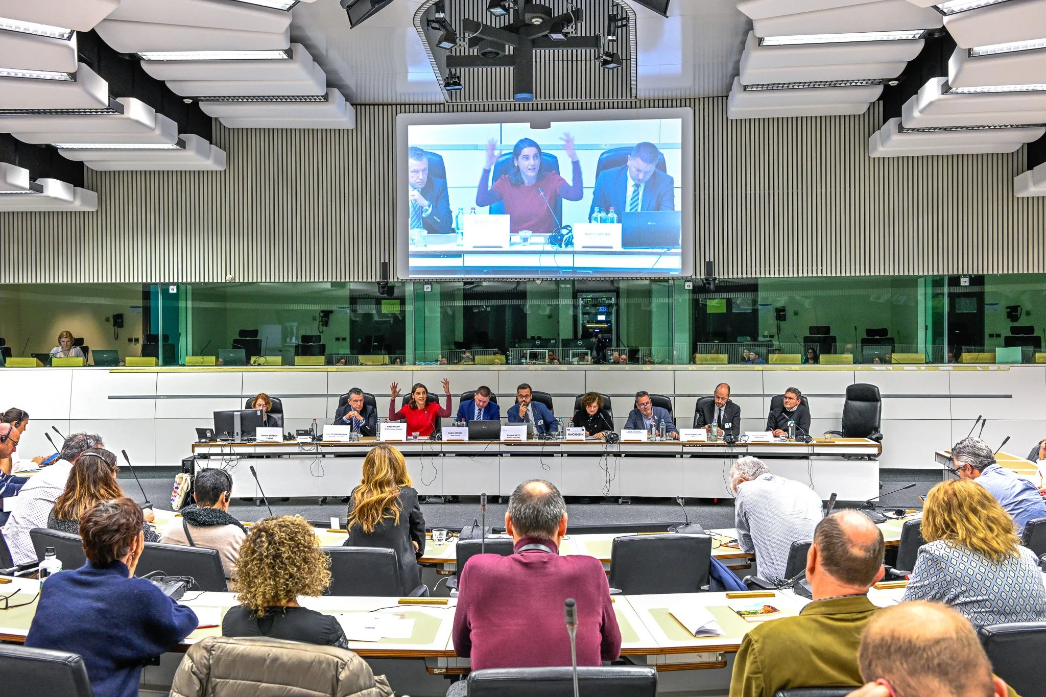 Salle de conférence avec des participants et un écran de présentation.