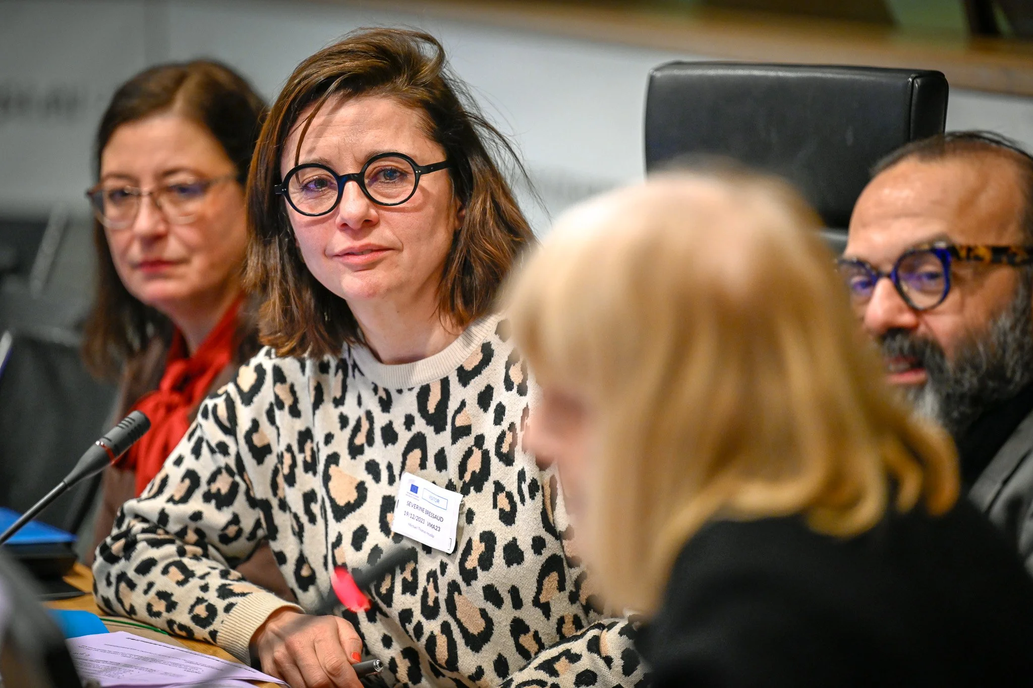 Groupe de personnes assises à une table, participant à une réunion.