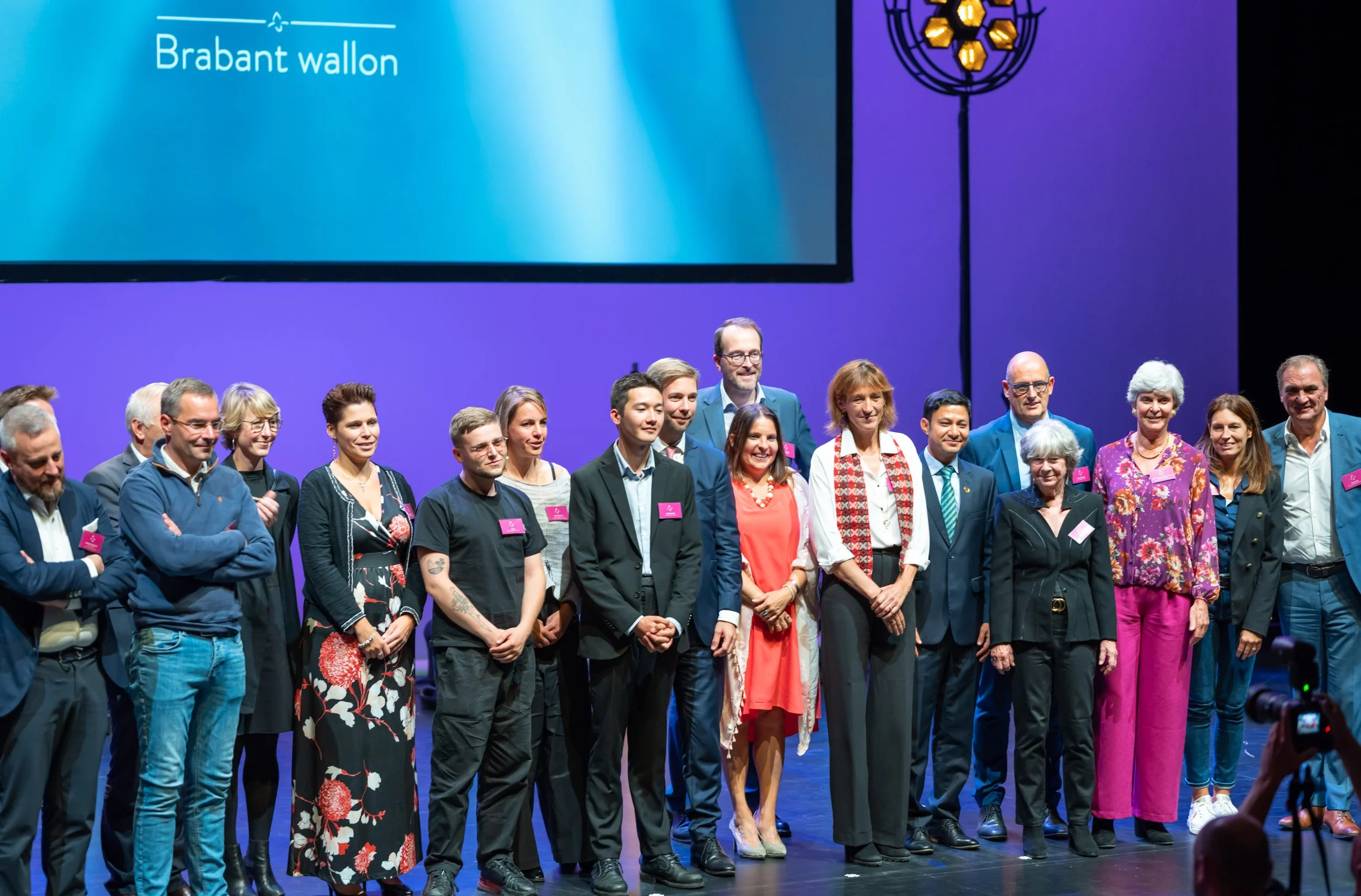 Photo de famille réalisée par un photographe professionnel à Wavre et qui montre sur la scène de La Sucrerie à Wavre les lauréats du prix "Orchidée du Brabant wallon