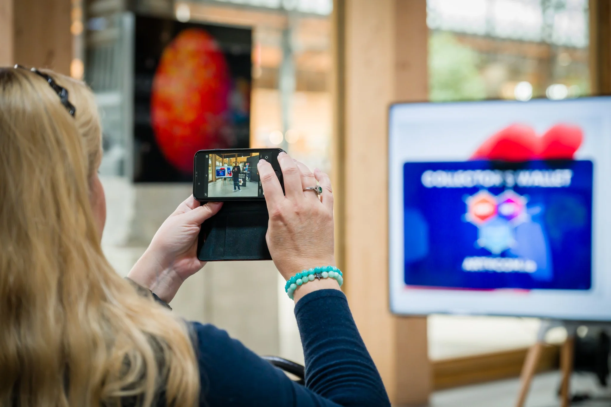 Photographie par un photographe professionnel pendant une conférence. Personne prenant une photo avec un smartphone lors d'un événement, écran et peinture en arrière-plan.