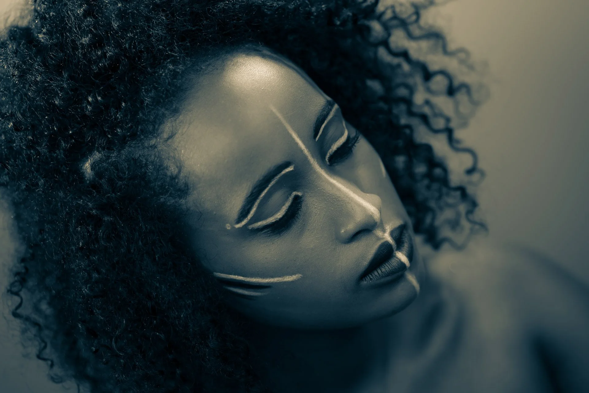Portrait d'une femme avec un maquillage artistique blanc, sur un fond neutre.