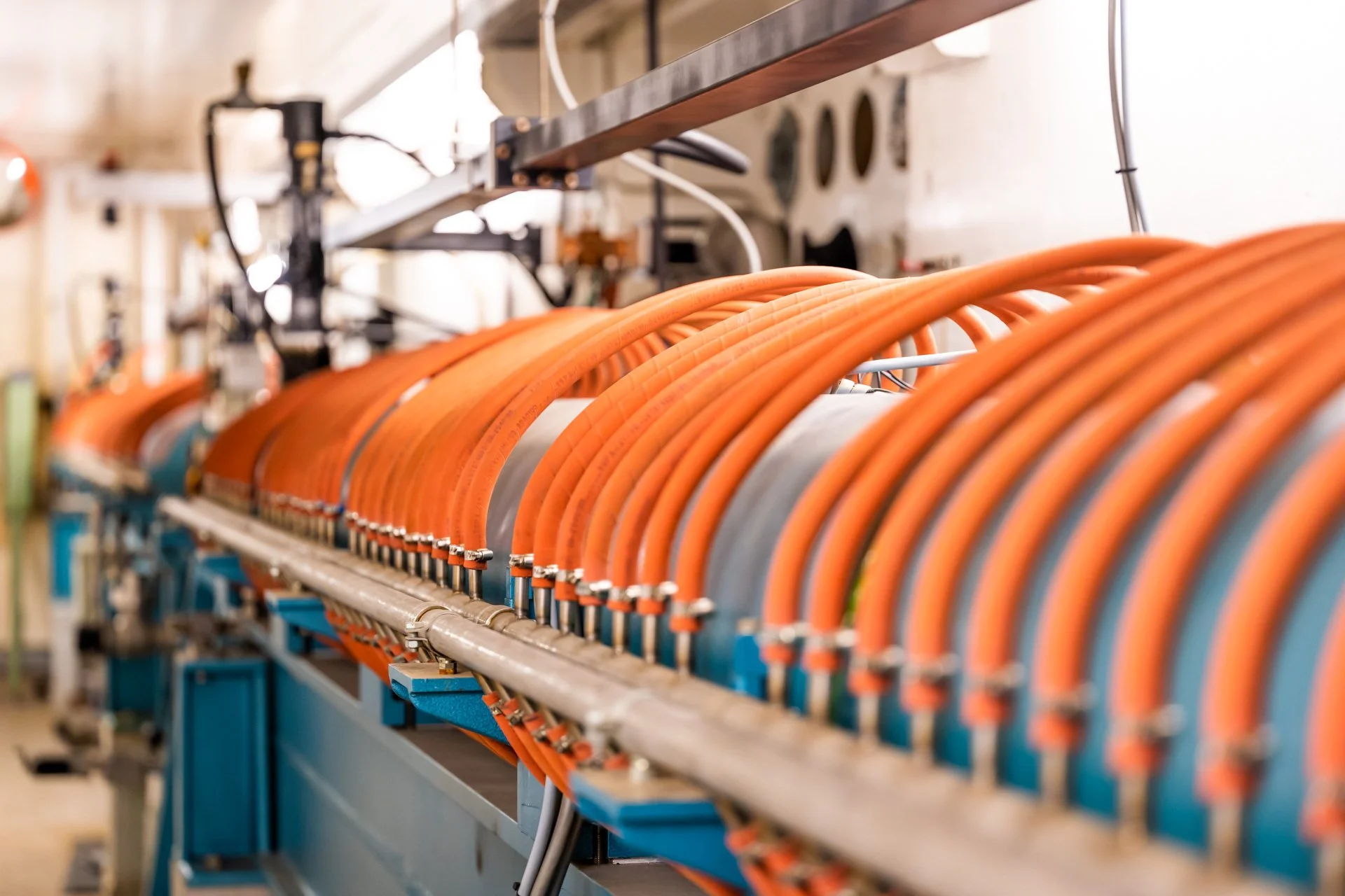 Câbles orange et un équipement électrique industriel dans un environnement technique.