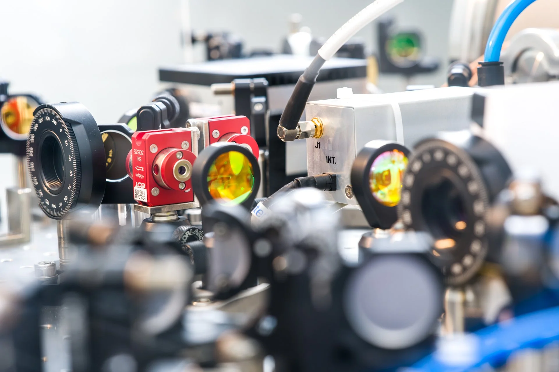 Photo d'entreprise d'un équipement de laboratoire optique avec dispositifs de lentilles et composants techniques.