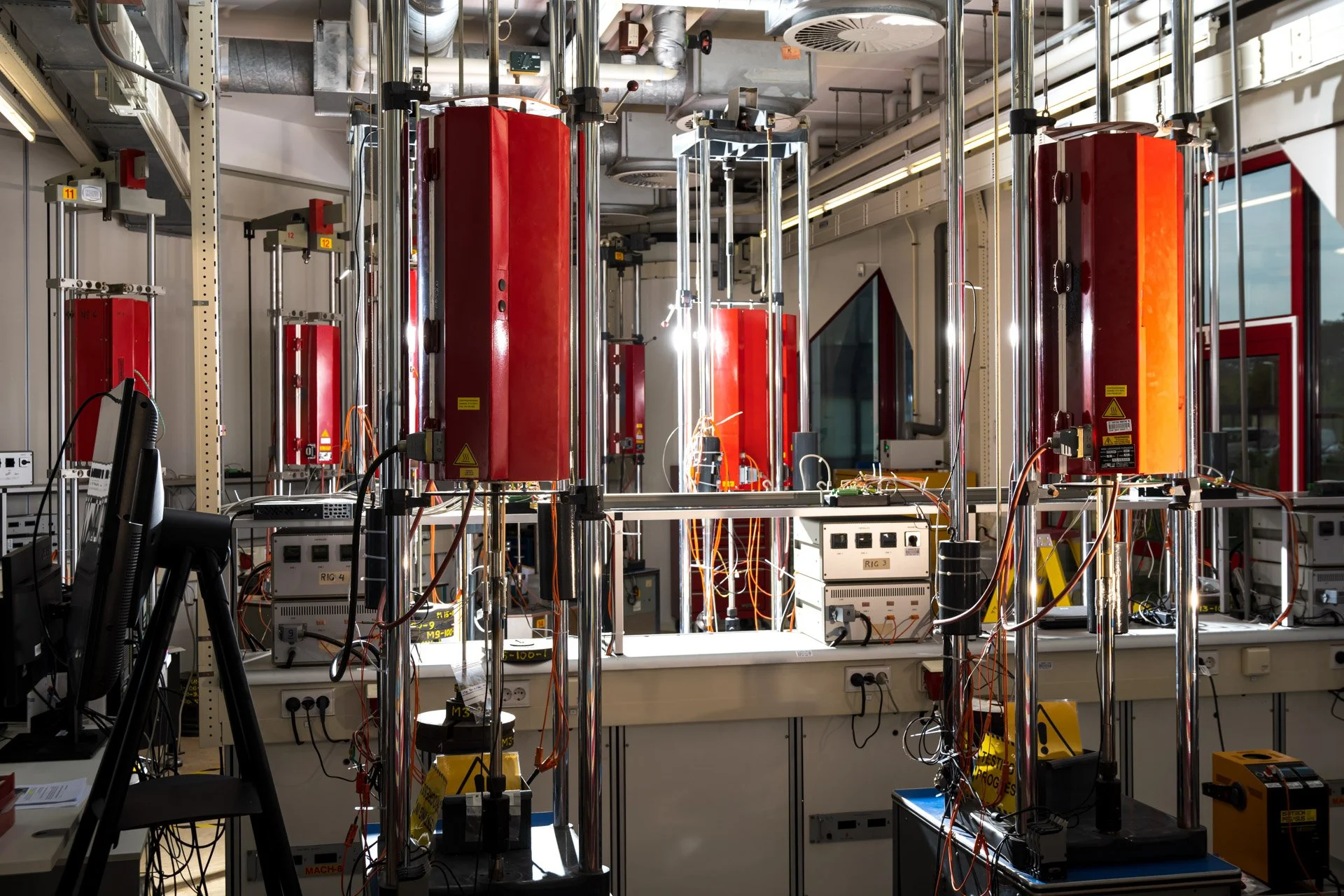Photo corporate de l'intérieur d'un laboratoire avec des équipements techniques et câbles électriques.