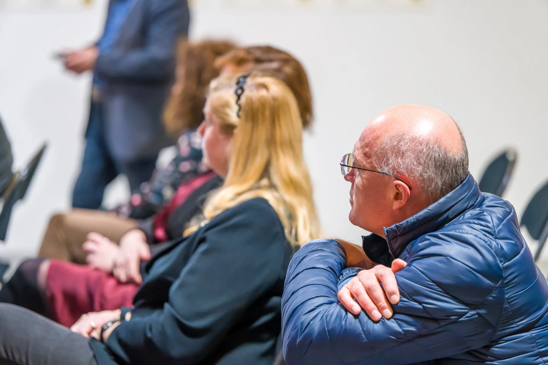 People sitting down, listening attentively to a presentation or lecture.