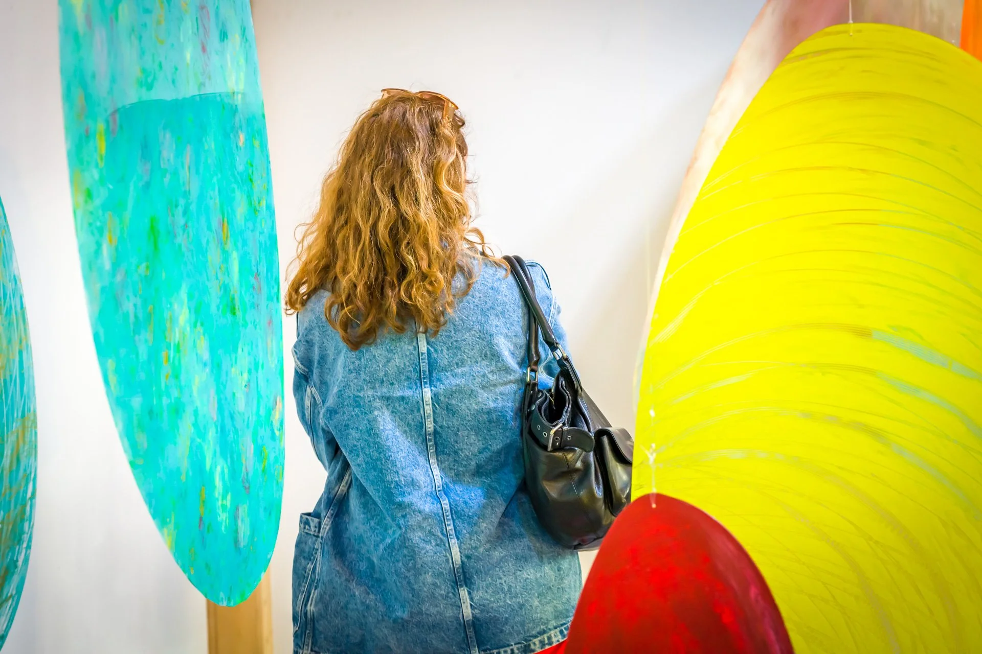 Personne regardant des œuvres d'art colorées dans une galerie.