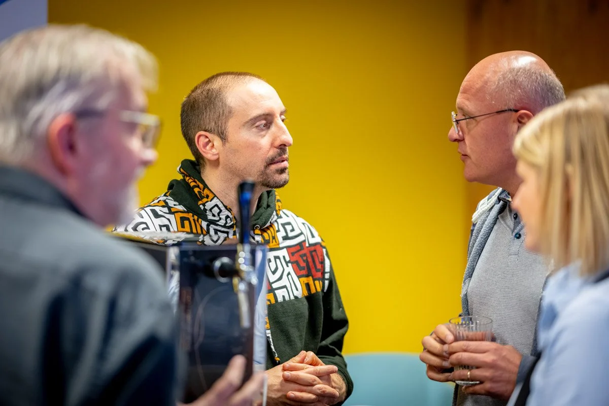 Grégory Monfort et Bruno Lambotte discutent avec d’autres participants lors du meetup WalChain à Charleroi.
