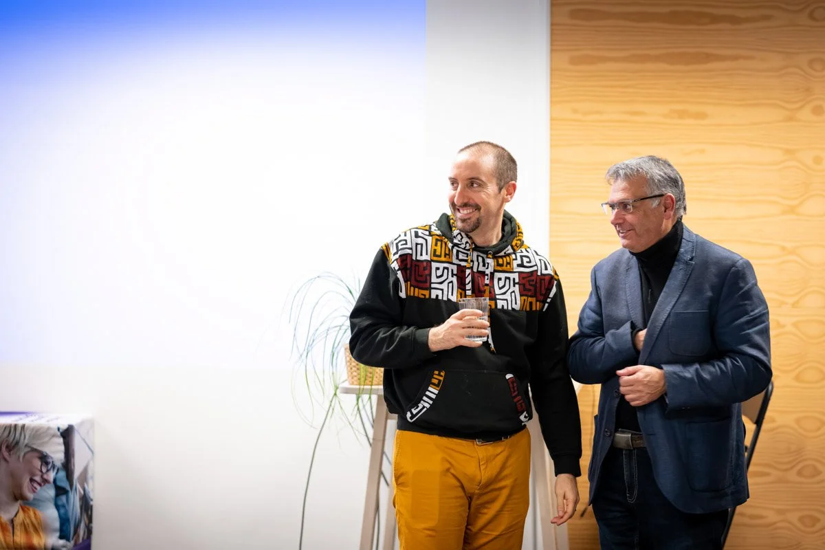 Grégory Monfort et Vincent Parissis échangent debout près d’un écran de projection lors du meetup WalChain à Charleroi.