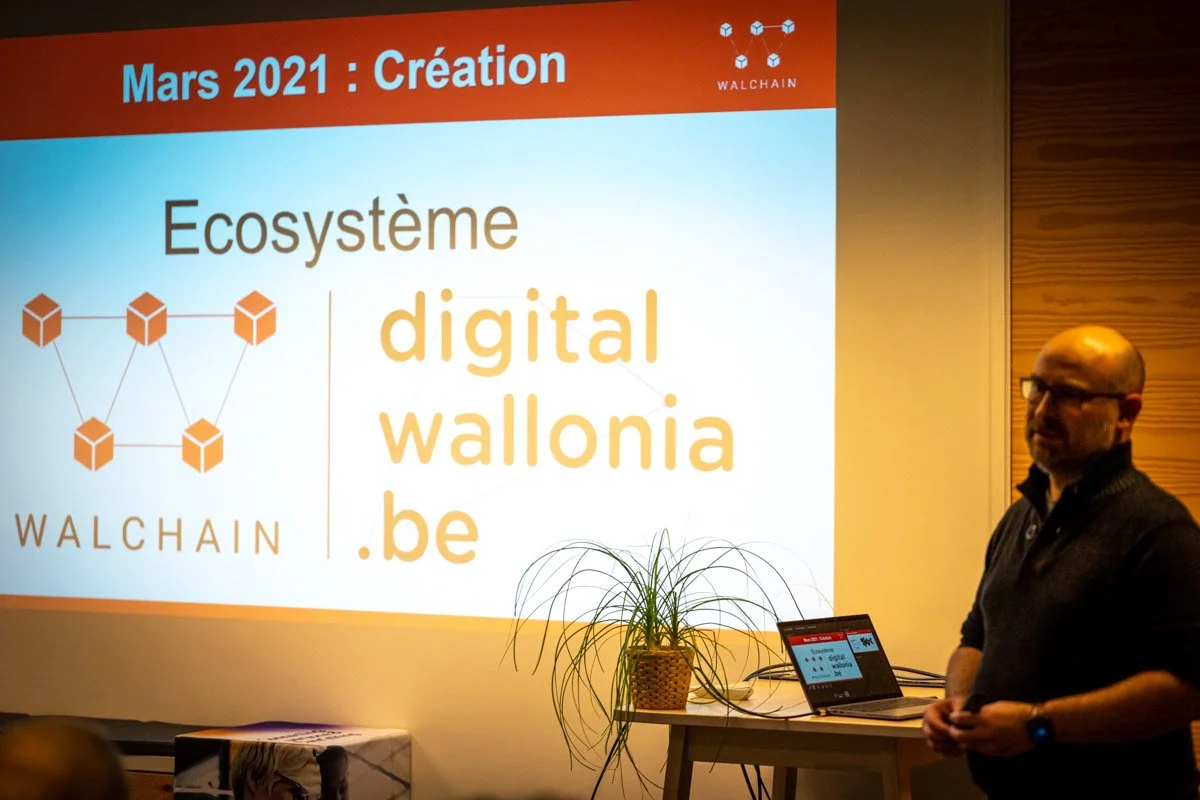 Denys Bornauw présente une diapositive sur l’écosystème Digital Wallonia et WalChain lors du meetup à Charleroi.