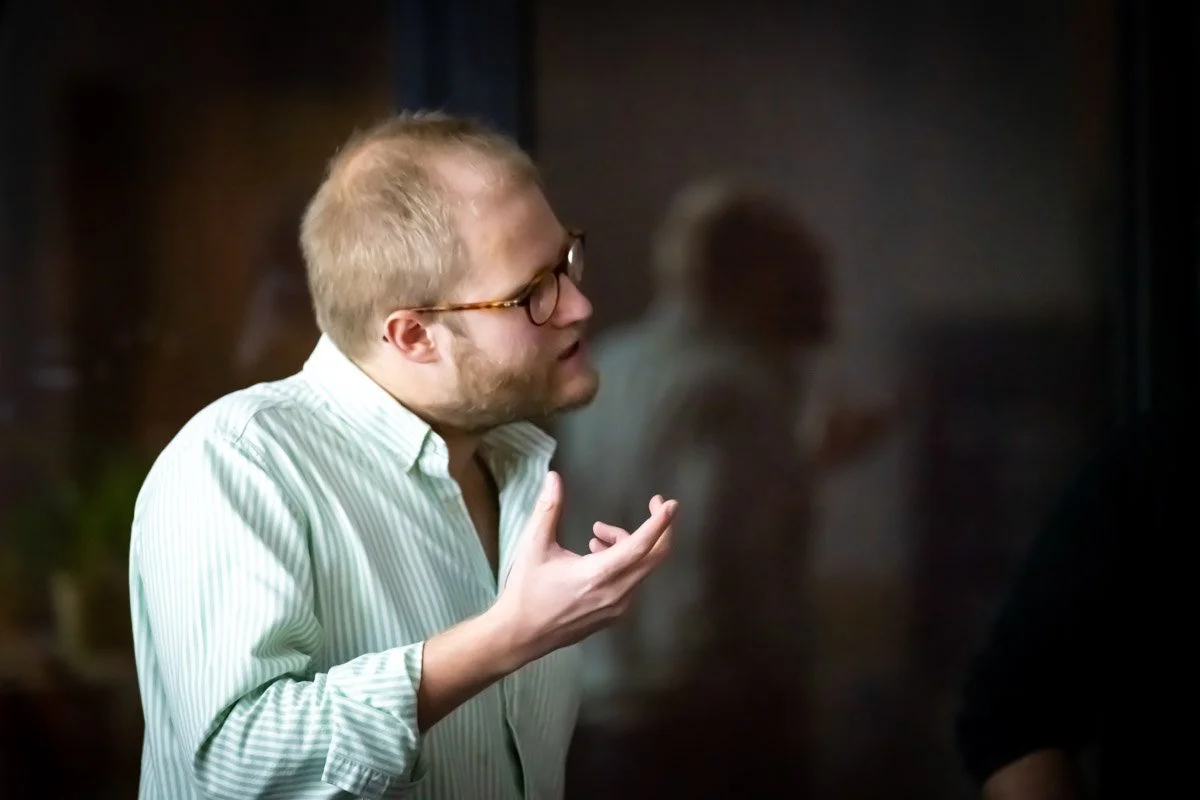 Henri Rion, vu de profil, accompagne ses propos d’un geste de la main lors du meetup WalChain à Charleroi.