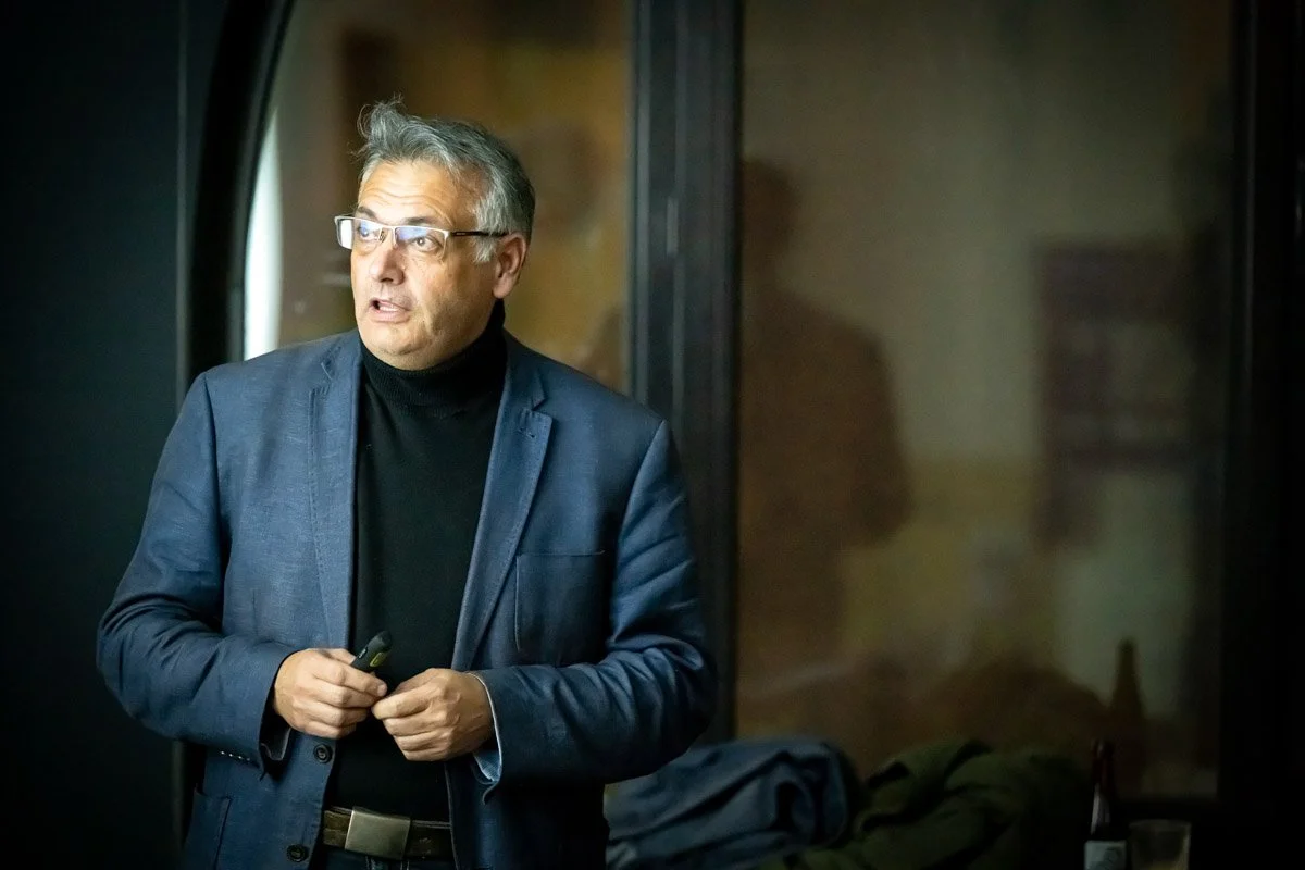 Vincent Parissis, en veste bleue et col roulé noir, intervient lors du meetup WalChain à Charleroi.