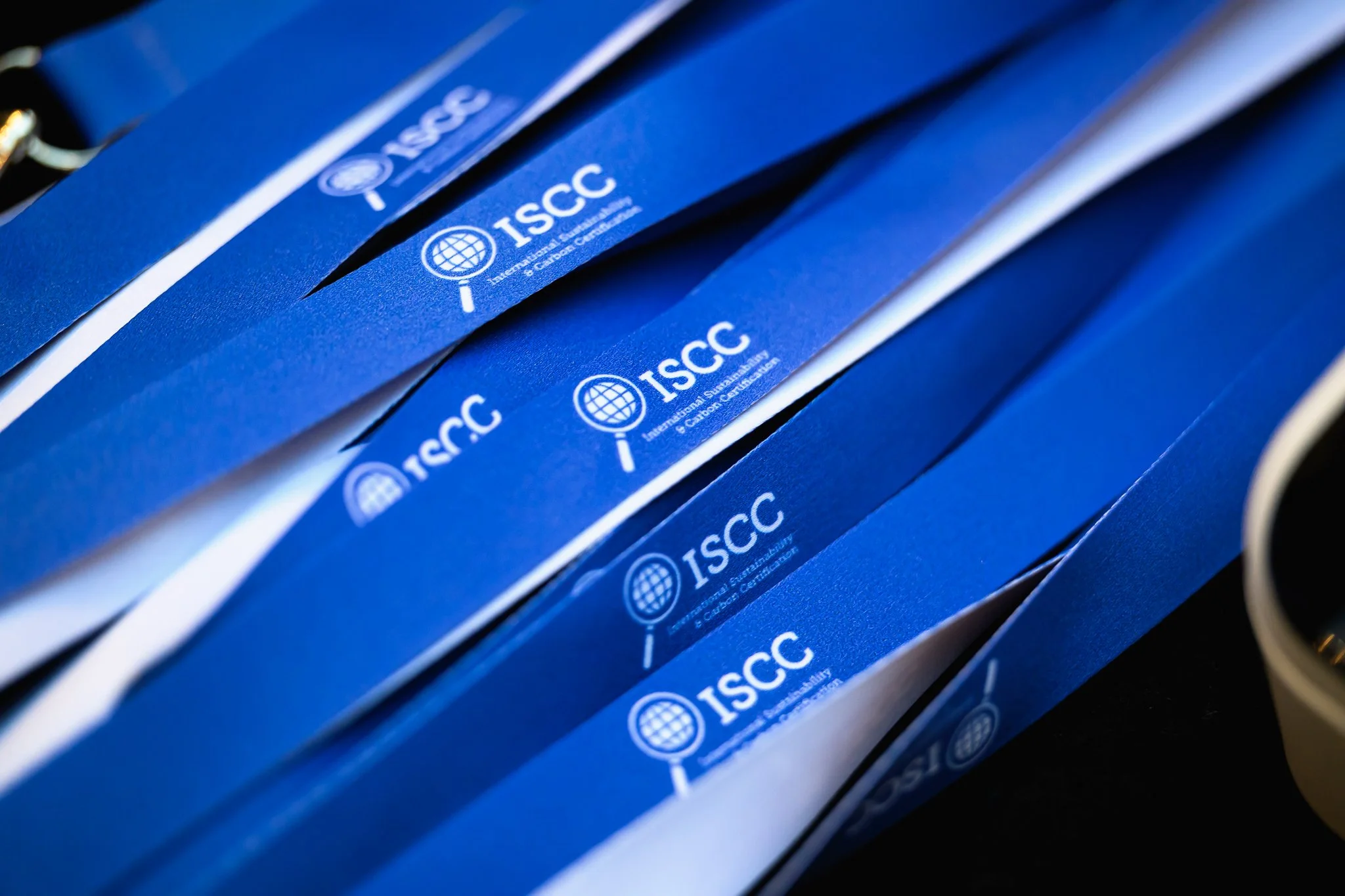 Close-up of overlapping blue lanyards printed with the ISCC logo.