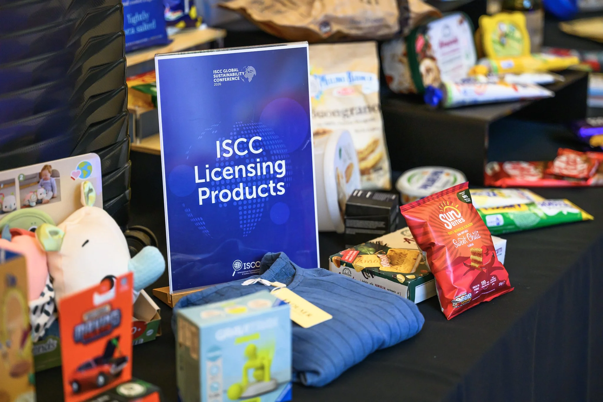 Packaged products and a folded blue garment are displayed beside an ISCC Licensing Products sign.