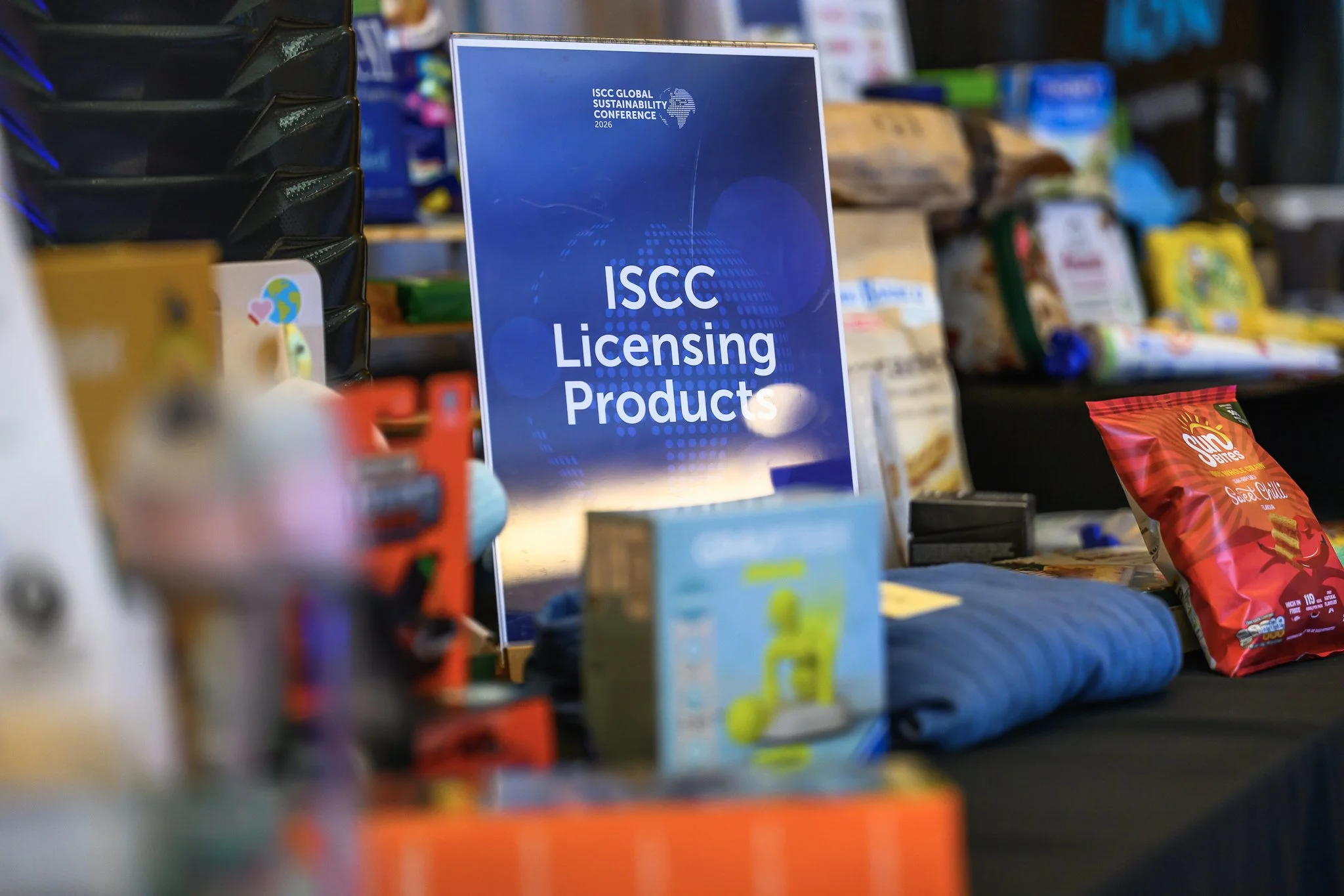 An ISCC Licensing Products sign stands among packaged products on a display table.