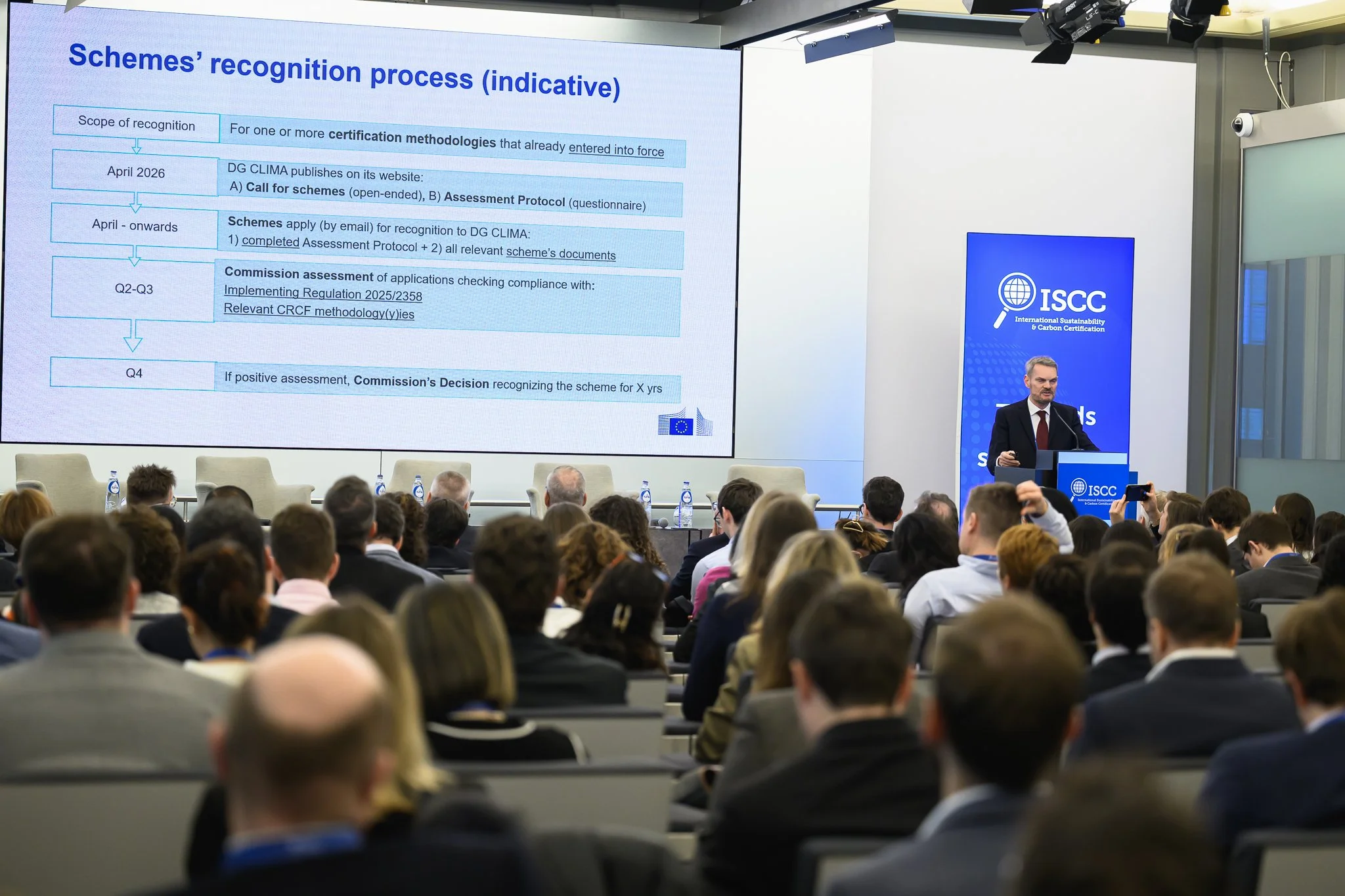 A wide view of the audience facing a slide about the recognition process for certification schemes.
