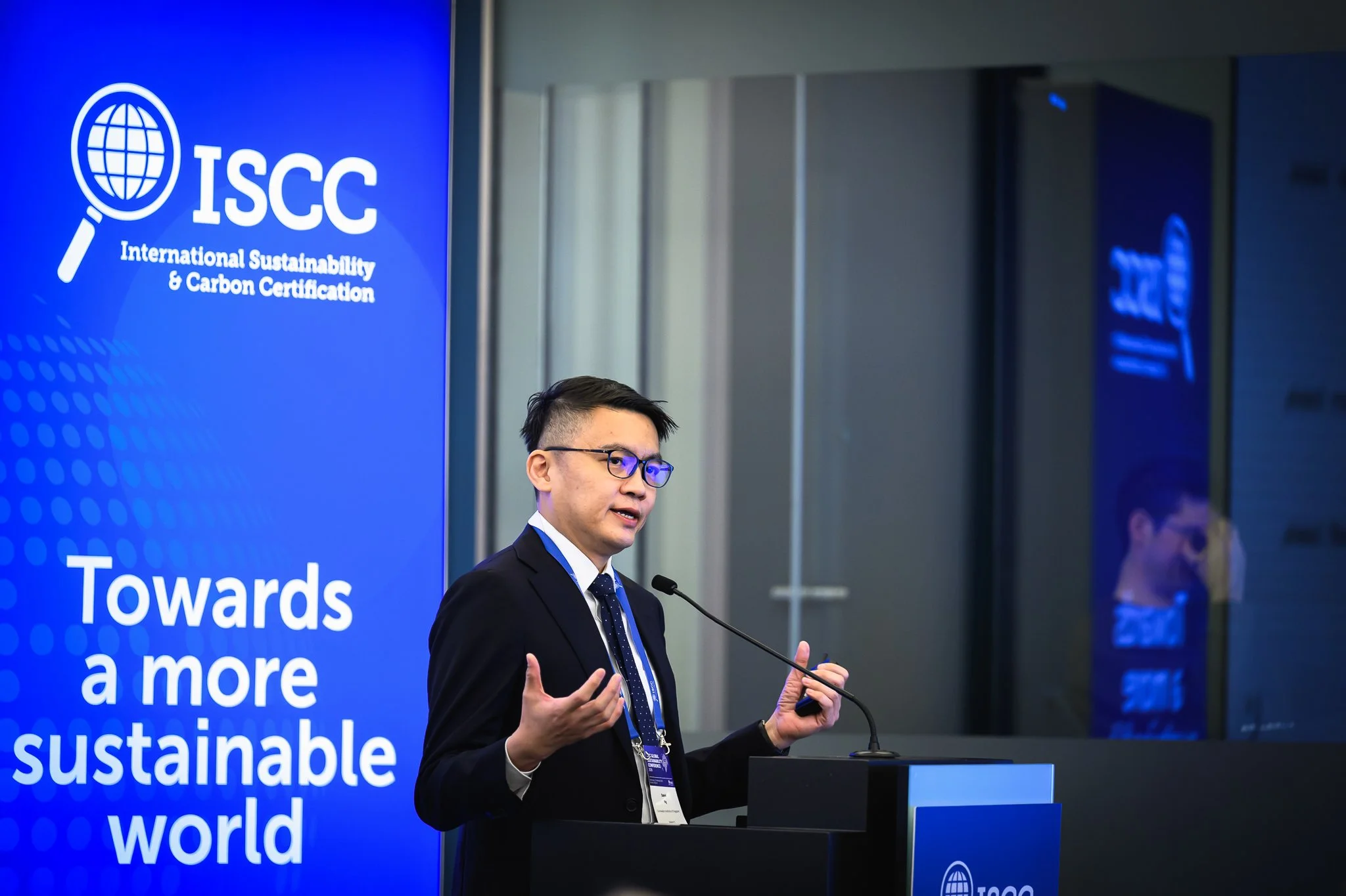 A man in glasses gestures with both hands during his presentation.