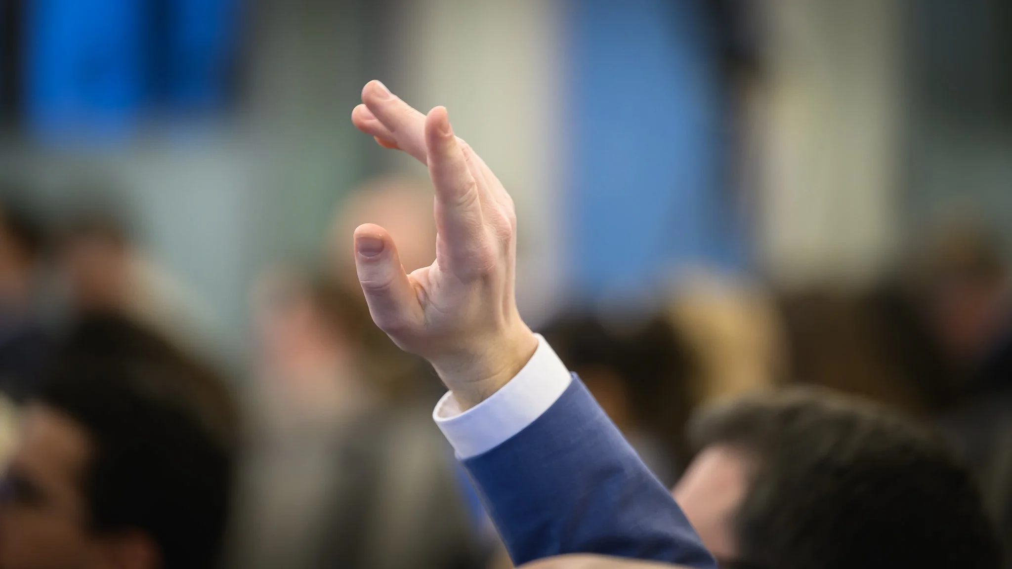 Close-up of an audience member's raised hand.