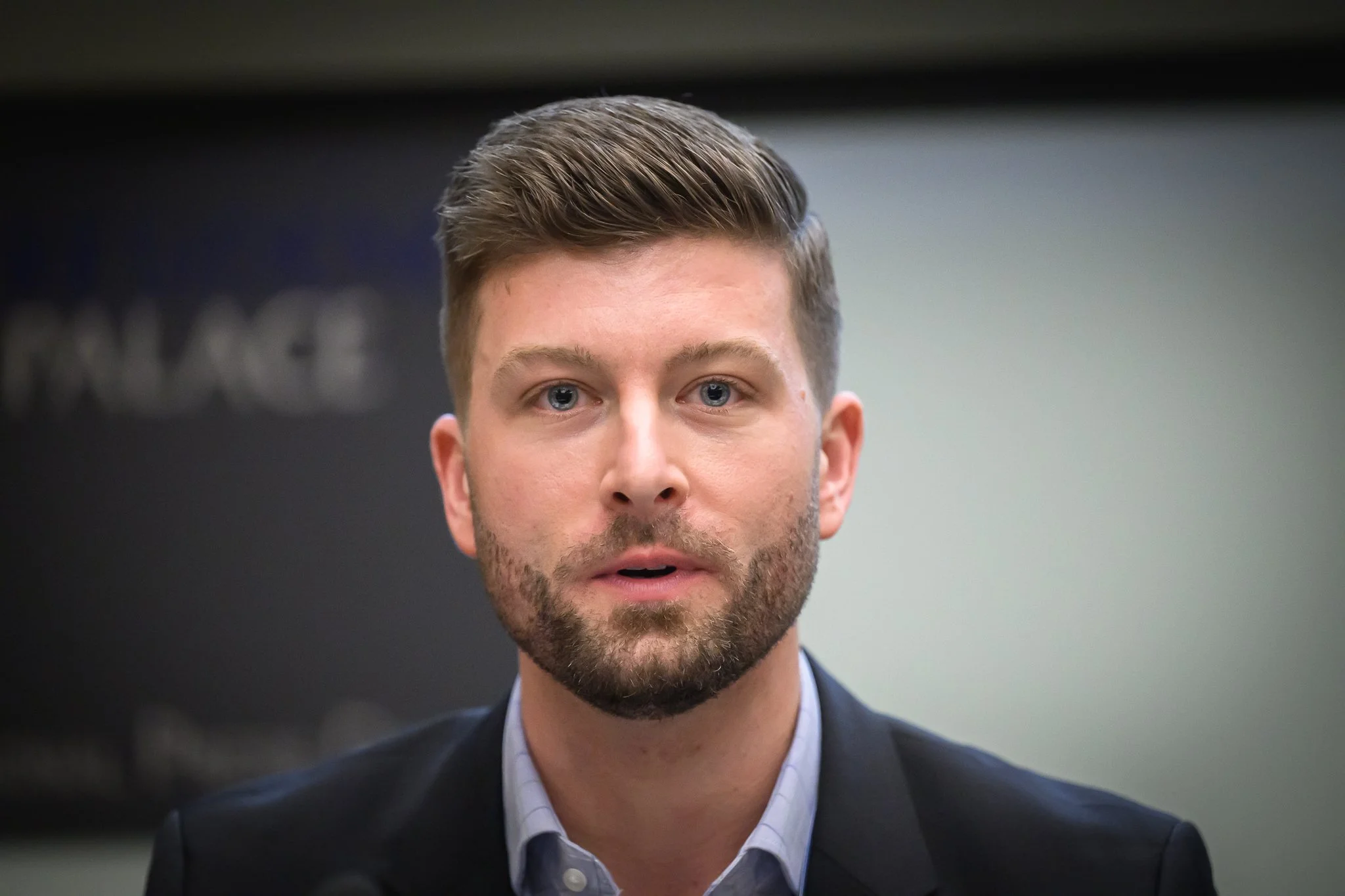 Close-up of a bearded man listening at a conference table.
