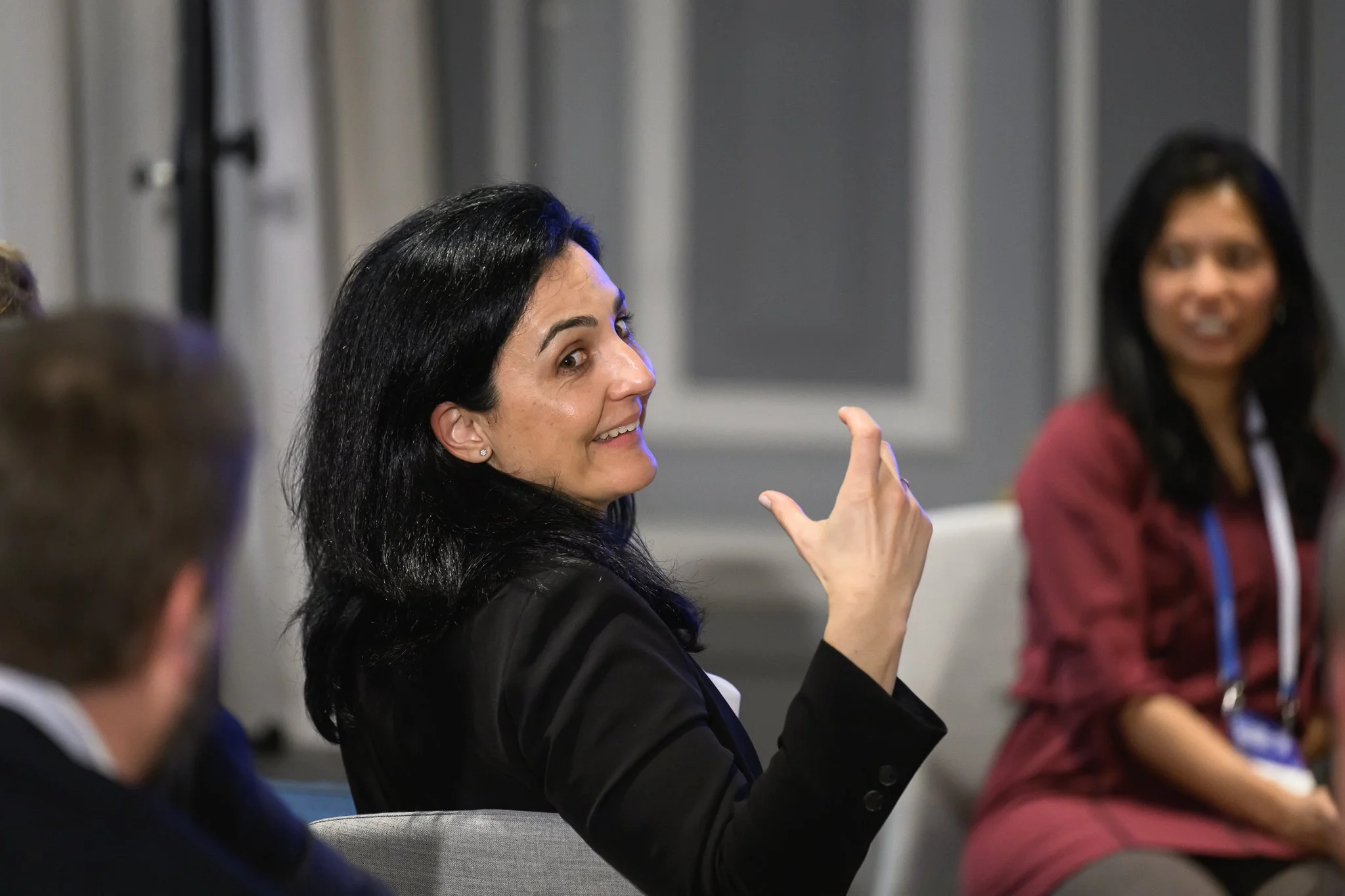 A seated woman gestures with one hand during a discussion.