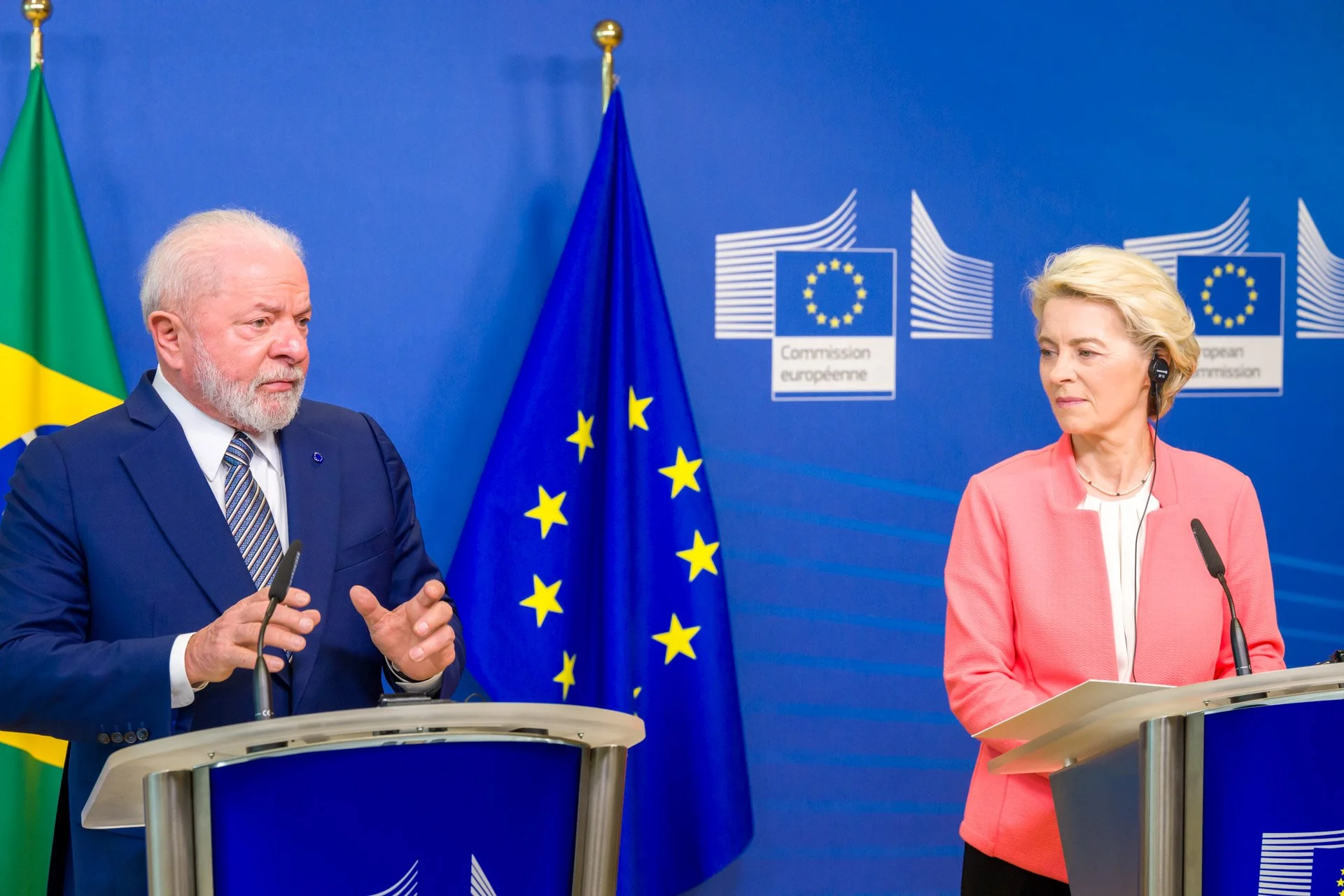 Deux personnes discutant lors d'une conférence de presse, devant les drapeaux brésilien et européen, avec le logo de la Commission européenne en arrière-plan.