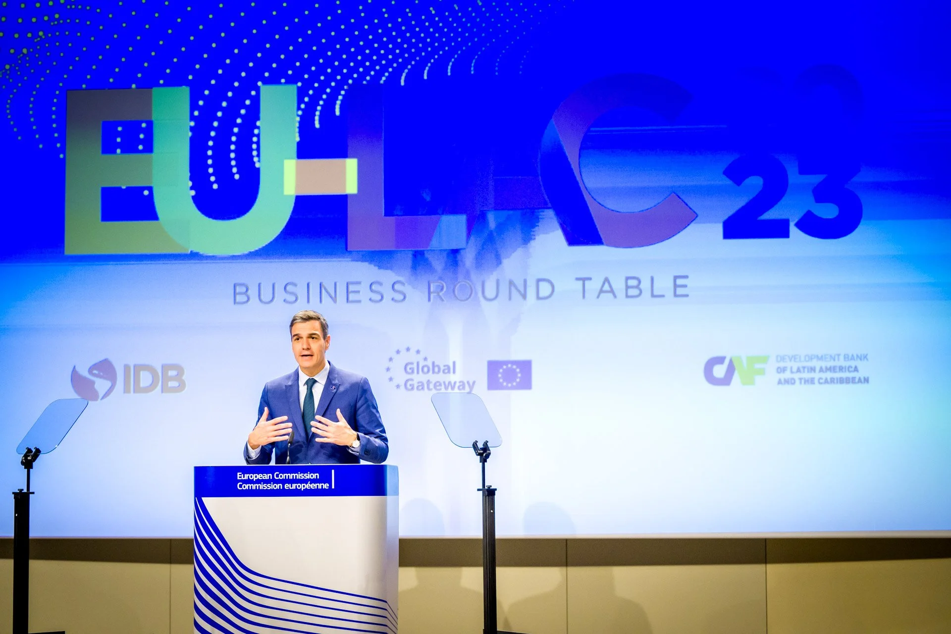 Un conférencier s'exprime lors de la table ronde "EU-LAC 23 Business Round Table", avec des logos de la Commission européenne, Global Gateway, IDB et CAF en arrière-plan.