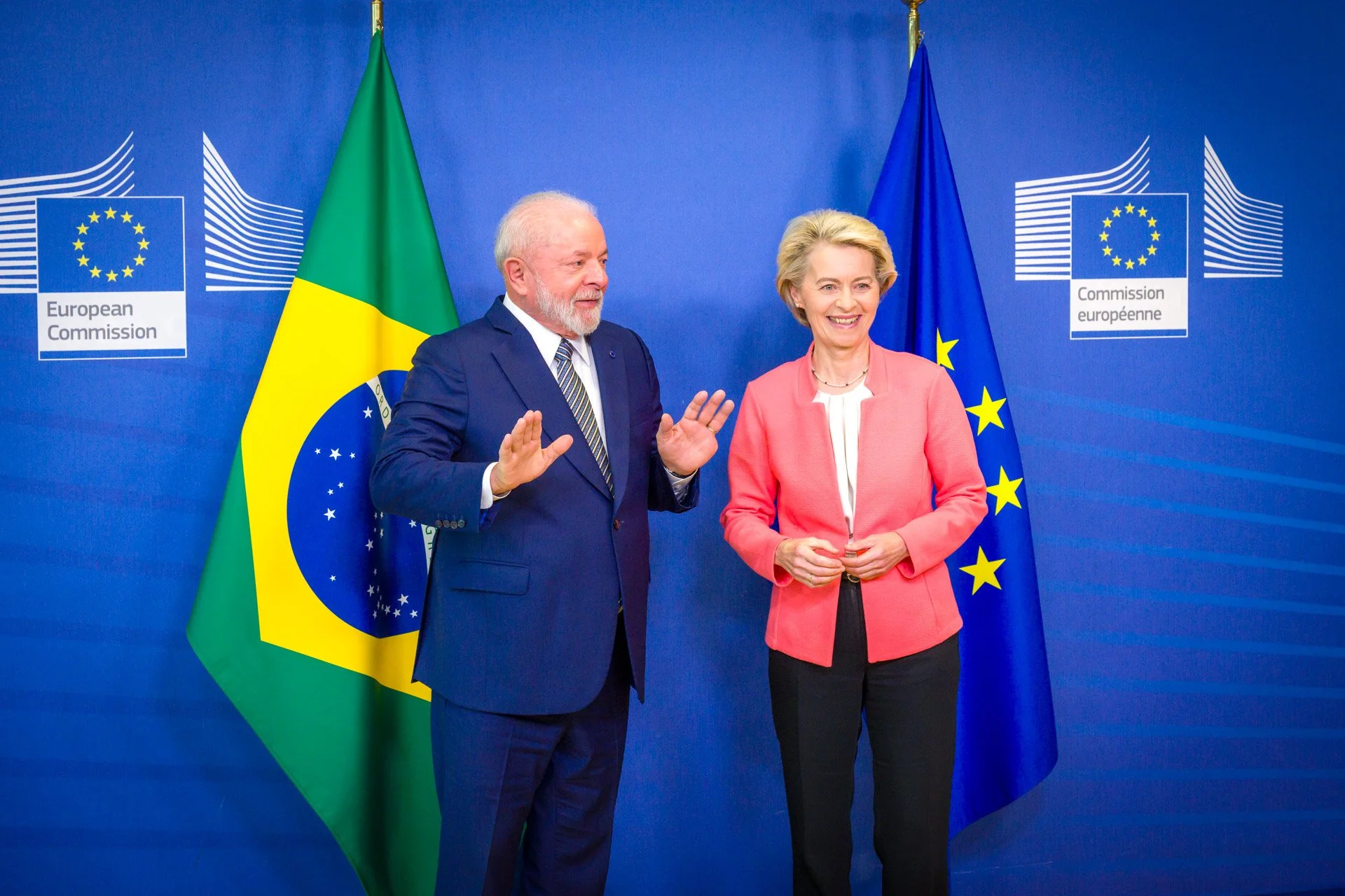 Deux personnes devant les drapeaux du Brésil et de l'Union européenne à la Commission européenne.