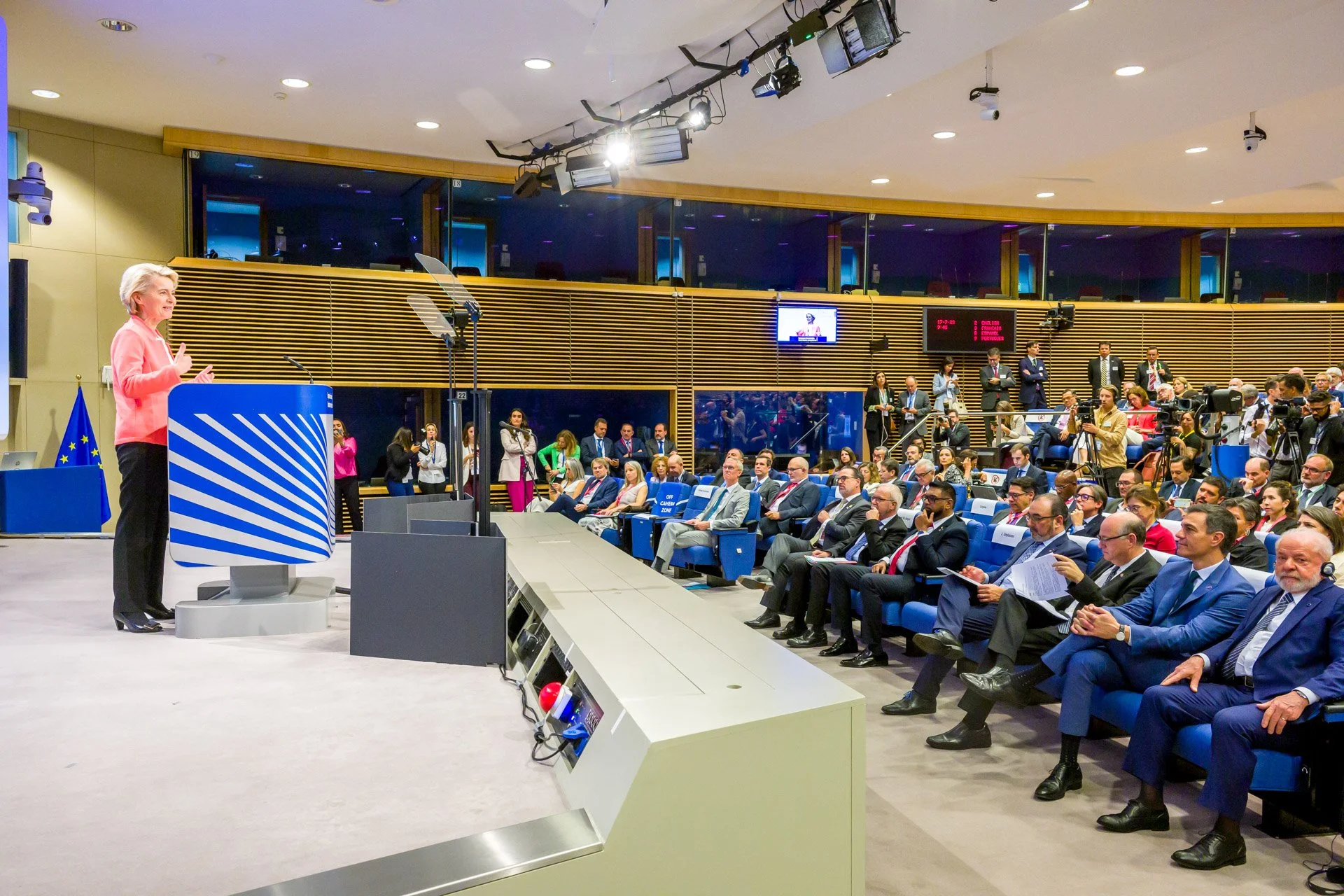 Conférence de presse à la Commission européenne avec une oratrice et des participants assis, fond de drapeau de l'UE.