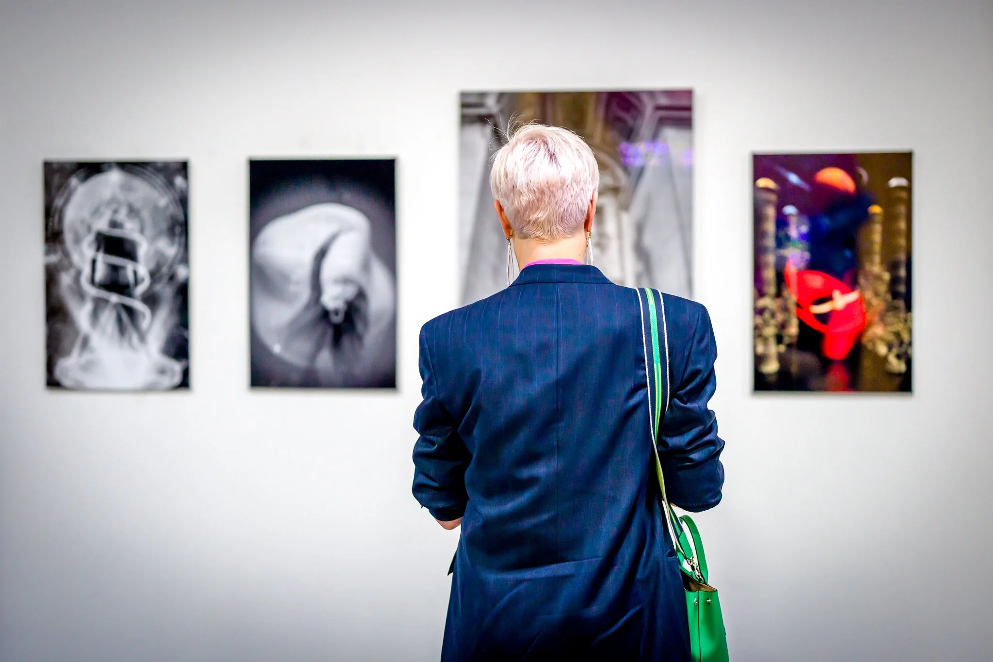Une personne regarde des œuvres d'art accrochées au mur d'une galerie.