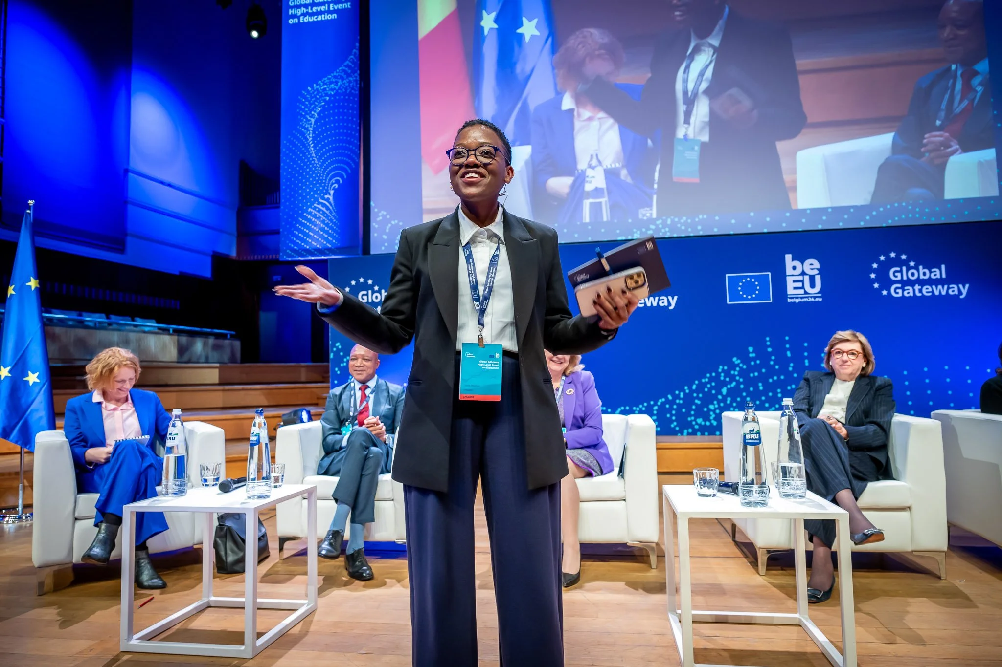 A conference with speakers in formal attire on stage, the EU flag, and a ‘Global Gateway’ sign in the background.