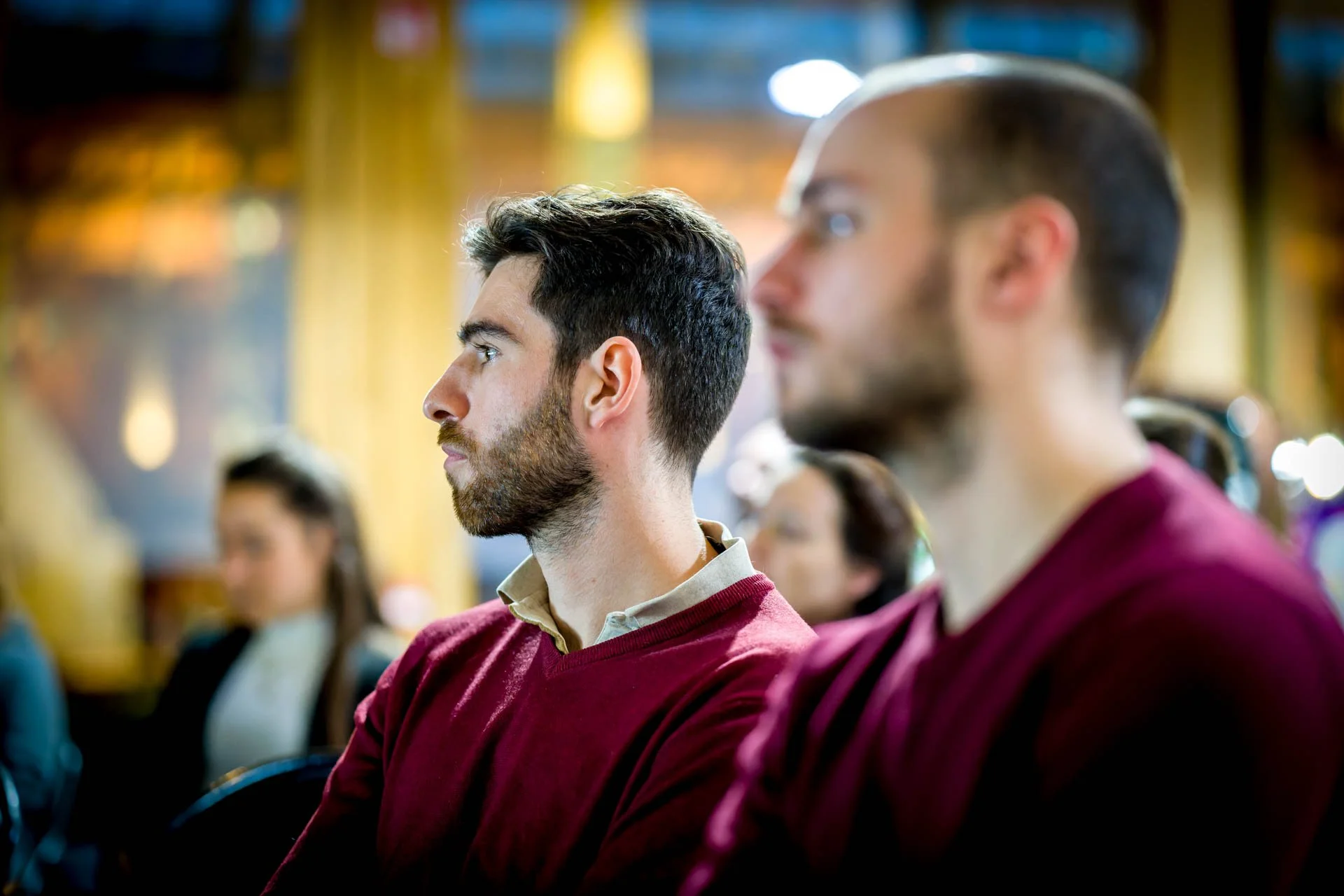Un groupe de personnes assises et attentives lors d'une conférence ou d'un séminaire.